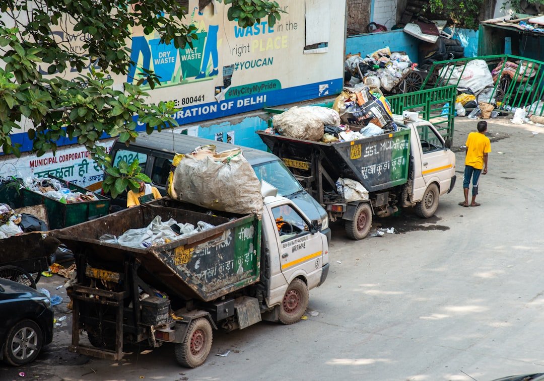 A municipal garbage truck in Delhi, India, filled with bags of dry waste and recyclables.